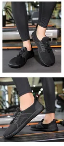 Dettaglio delle scarpe barefoot nere in mesh traspirante con lacci elastici regolabili