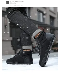 Outdoor action shot of black waterproof winter snow boots with tread soles on snowy ground