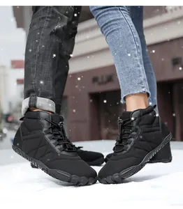 Waterproof winter snow boots for men and women showing textured grip sole in the snow