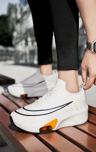 Gros plan sur la chaussure de course blanche respirante avec coussin d'air orange vif