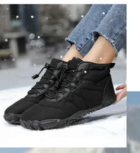 Detail of waterproof black winter snow boots on snowy ground with a thick anti-slip rubber sole