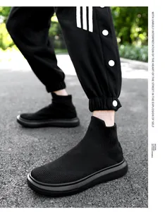 Close-up of black knit sock sneakers with thick rubber soles and breathable fabric