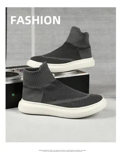 Detail view of high-top knitted sock sneakers with elastic cuffs on a decorative stage