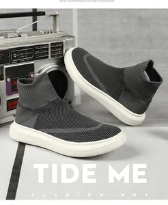 Detail view of high-top knit sock sneakers in dark grey with thick white rubber soles