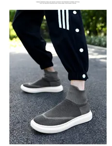 Detail of dark grey knit sock sneaker with white thick sole shown on a male model outdoors