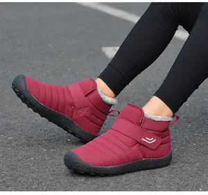 Outdoor-Aufnahme weinroter Schneestiefel mit Klettverschluss und warmem Kunstfellfutter