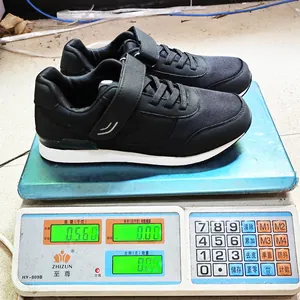 Detailed view of lightweight black walking sneakers on a scale showing product weight