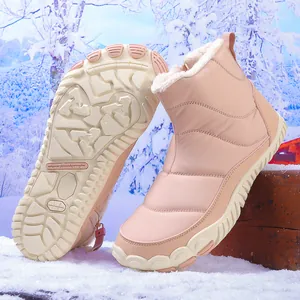Detail of pink winter snow boot with thick faux fur lining on a snowy outdoor log