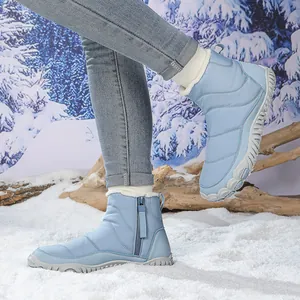 Detailed view of light blue waterproof snow boot with warm faux fur lining on snow