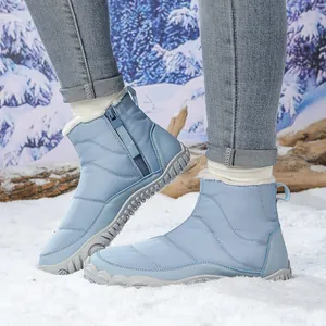 Detailed view of light blue quilted snow boots with white faux fur lining and side zipper