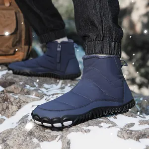 Detail of waterproof blue snow boots with warm faux fur lining and side zipper on snow