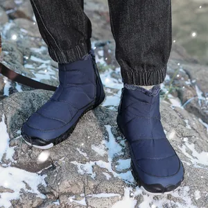 Navy waterproof winter boot with warm faux fur lining and anti-slip rubber sole on snow