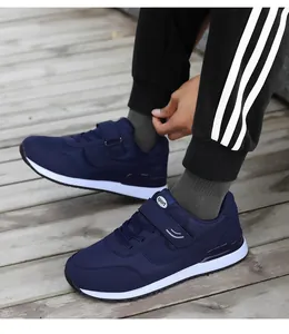 Detail of navy blue walking shoe with hook-and-loop strap on breathable mesh fabric