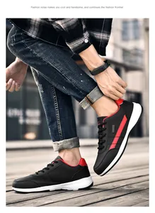 Nahaufnahme schwarzer Leder-Sneaker mit roten Streifen an einem Streetstyle-Model
