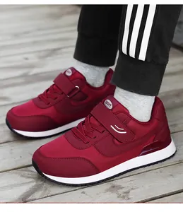 Macro detail of wine red walking shoe featuring adjustable velcro strap and mesh fabric