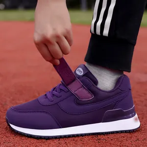 Purple senior walking shoe with velcro strap and breathable mesh on running track