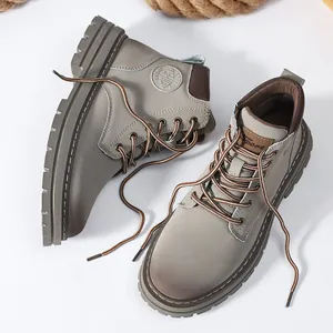 Detail view of khaki work boots featuring thick rubber lug soles and fashion sports logo
