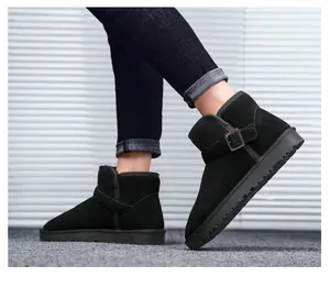 Close-up of black suede snow boot featuring a stylish metal buckle strap and thick rubber sole