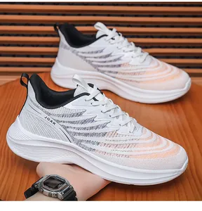 Detail of white breathable mesh running shoe with orange accents and JGAK branding