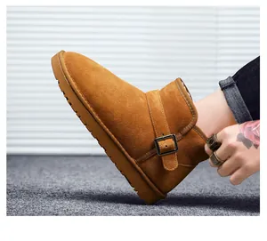 Close-up of camel leather snow boot with metal buckle strap and warm plush lining