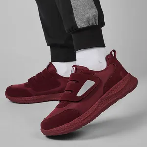 Dettaglio di scarpe da camminata bordeaux con calzata ampia e suola spessa antiscivolo