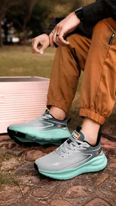 Outdoor shot of men's winter sports shoes with grey and mint green mesh texture and thick sole