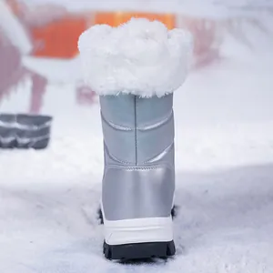 Achteraanzicht van zilveren sneeuwlaarzen met dik wit imitatiebont op de sneeuwgrond