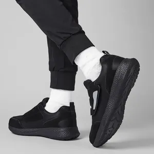 Dettaglio di scarpe da camminata nere con rete e velcro indossate da un modello