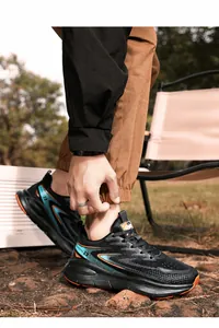 Detail of men's athletic running shoe with vibrant blue and orange accents on grass