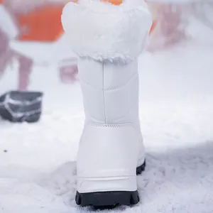 Detail von weißem wasserdichtem Schneestiefel mit Kunstpelz auf verschneitem Grund