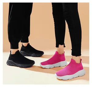 Dettaglio di sneaker in maglia traspirante nere e rosso rosa con suole spesse