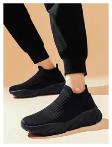Dettaglio di sneaker in maglia nera con suola spessa in gomma dal design ondulato