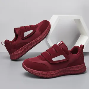 Dettaglio di scarpe da camminata bordeaux con chiusura a velcro e suola spessa antiscivolo