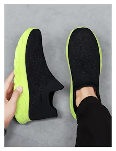 Macro detail of breathable black knitted upper and neon green platform sole for sport shoes