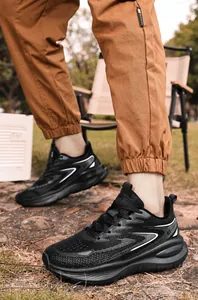 Detail of black breathable mesh sneakers with white wavy lines and thick midsole