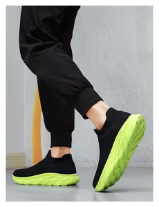 Detail of black knit sock sneaker featuring thick neon green platform sole and street style