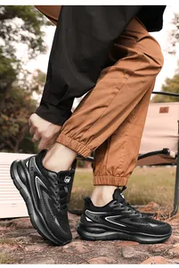 Outdoor close-up of men's black running shoes with white dynamic lines and thick soles
