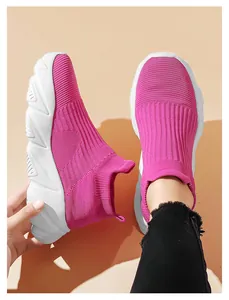 Dettaglio della sneaker in maglia rosa al piede con spessa suola in gomma bianca e trama tessuta