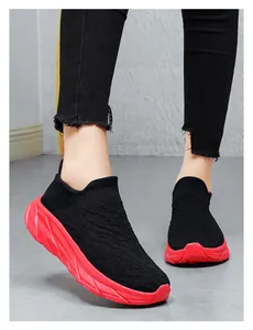 Action shot of breathable black knitted sock sneakers with thick red cushioned soles