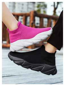Dettaglio delle sneakers in maglia rosa e nera con suole spesse e traspiranti geometriche
