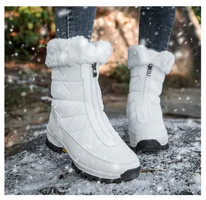Detail van witte sneeuwlaarzen met voering van imitatiebont en waterdichte rits op rotsen