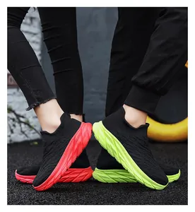 Detail of knit sock sneakers with thick non-slip soles in contrasting red and neon green