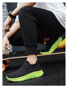 Close-up of black knit slip-on sneaker with neon green sole on a skateboard