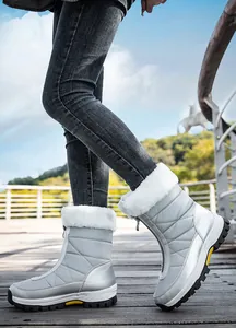 Detail van zilveren sneeuwlaarzen met dikke witte imitatiebontvoering en antislip rubberen zool