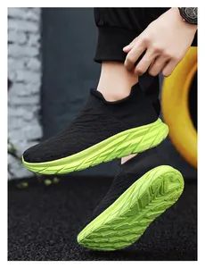 Macro view of men's knit sock sneakers with chunky neon green anti-slip rubber soles