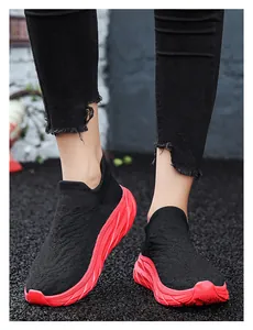 Detail of black knit sock sneakers with chunky red soles and V-pattern breathable fabric