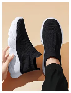 Dettaglio di sneaker a calzino in maglia nera leggera con suole bianche a onde