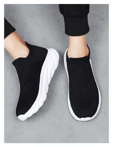 Close-up of black knit sock sneakers with textured fabric and thick white rubber soles