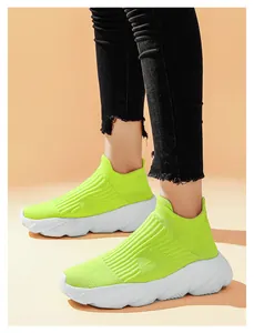 Dettaglio di sneakers slip-on in maglia giallo fluo con suola piatta bianca leggera