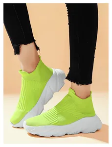 Vista indossata delle sneakers a calzino verde fluo da donna con suola platform bianca